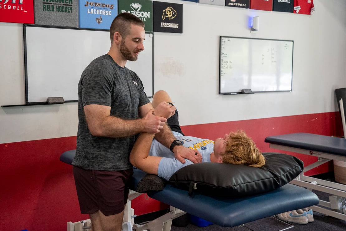  Patient working with a provider at a performance physical therapy clinic in Hudson, MA during a knee rehabilitation exercise session