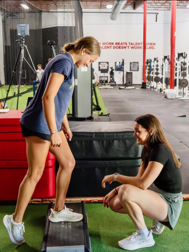 Physical therapist assessing runner's squat form and movement patterns at Hudson running clinic in Massachusetts Physical therapist assessing runner's squat form and movement patterns at Hudson running clinic in Massachusetts